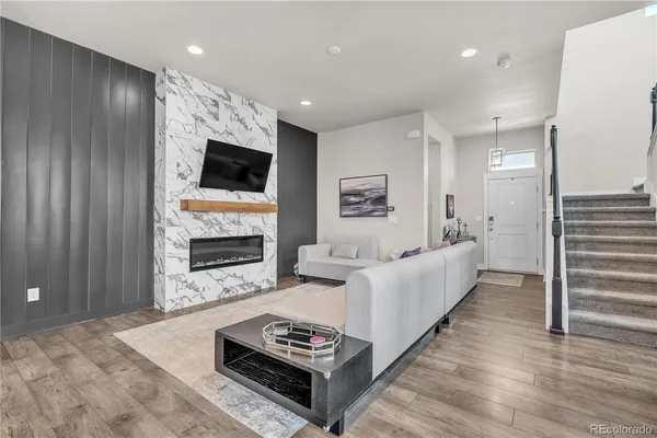 a living room with furniture a fireplace and a flat screen tv