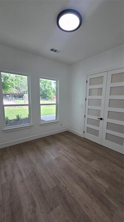 1106 East Sixth Street Springtown, TX 76082 - Photo 16 of 29 an empty room with wooden floor windows and entrance