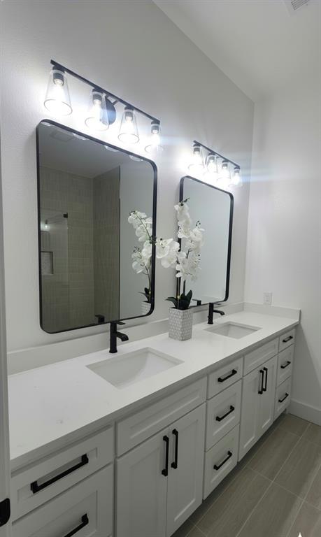 1106 East Sixth Street Springtown, TX 76082 - Photo 25 of 29 a bathroom with a double vanity sink and a mirror