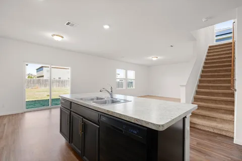 a view of kitchen with kitchen island a stove and white cabinets