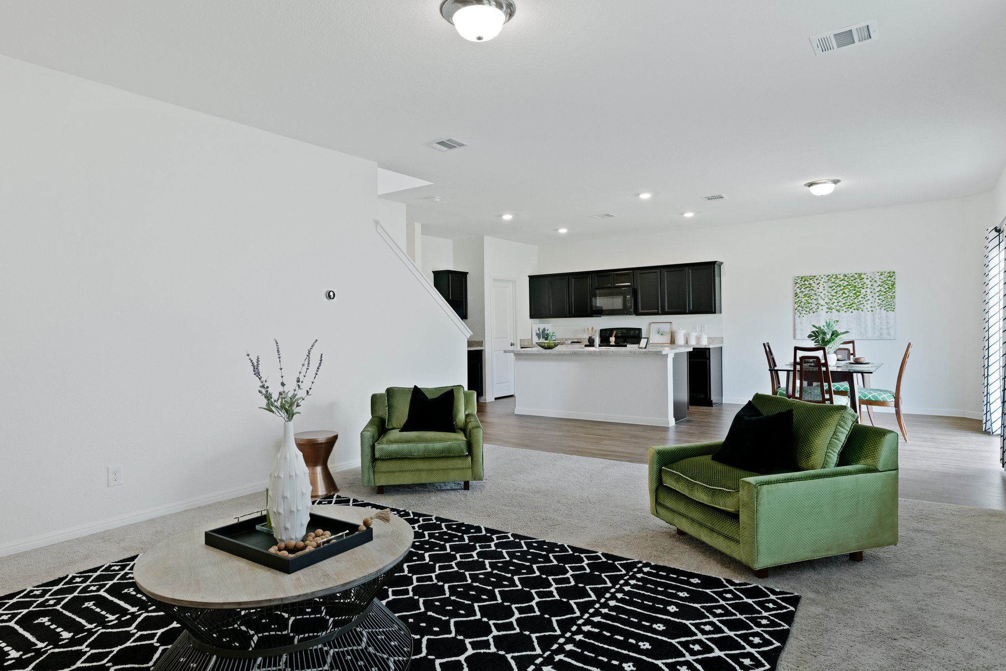 550 Bunton Reserve Boulevard Kyle, TX 78640 - Photo 7 of 32 The kitchen opens to a spacious living room featuring carpet flooring and a storage/media closet.