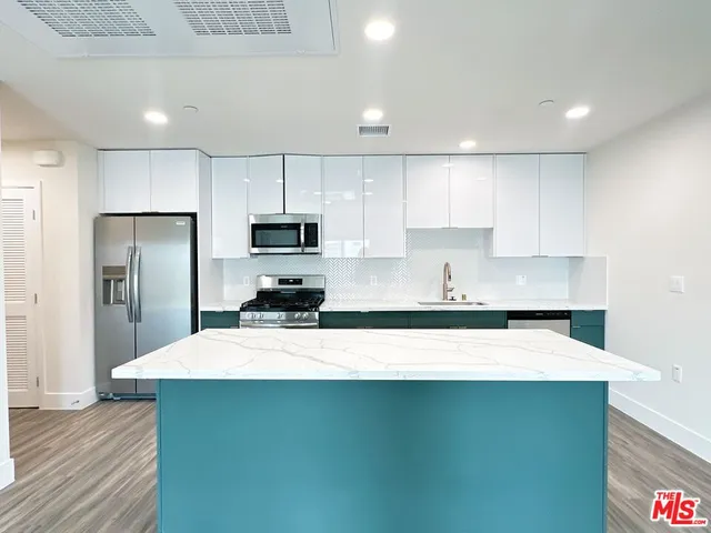 a kitchen with kitchen island a sink stainless steel appliances and cabinets