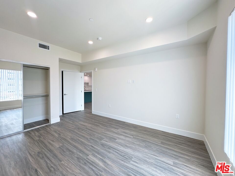 1037 Dewey Avenue, Unit 501 Los Angeles, CA 90006 - Photo 6 of 11 a view of an empty room with wooden floor and closet
