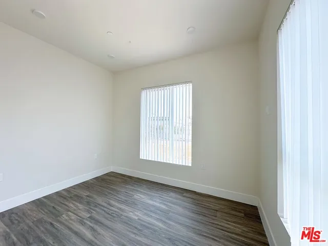 an empty room with wooden floor and window