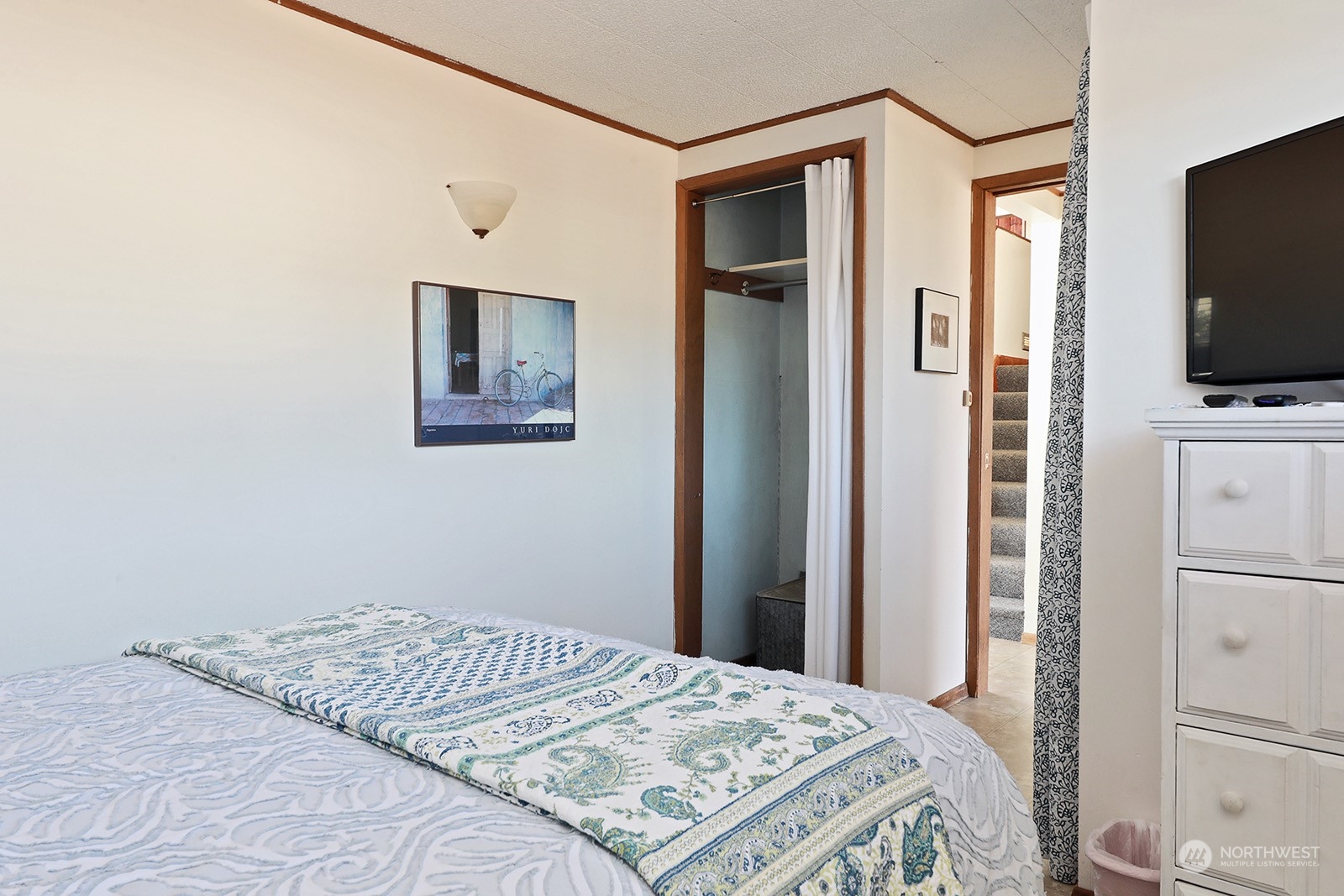 8166 Sandy Hook Drive Clinton, WA 98236 - Photo 21 of 40 a bedroom with a bed and a flat screen tv