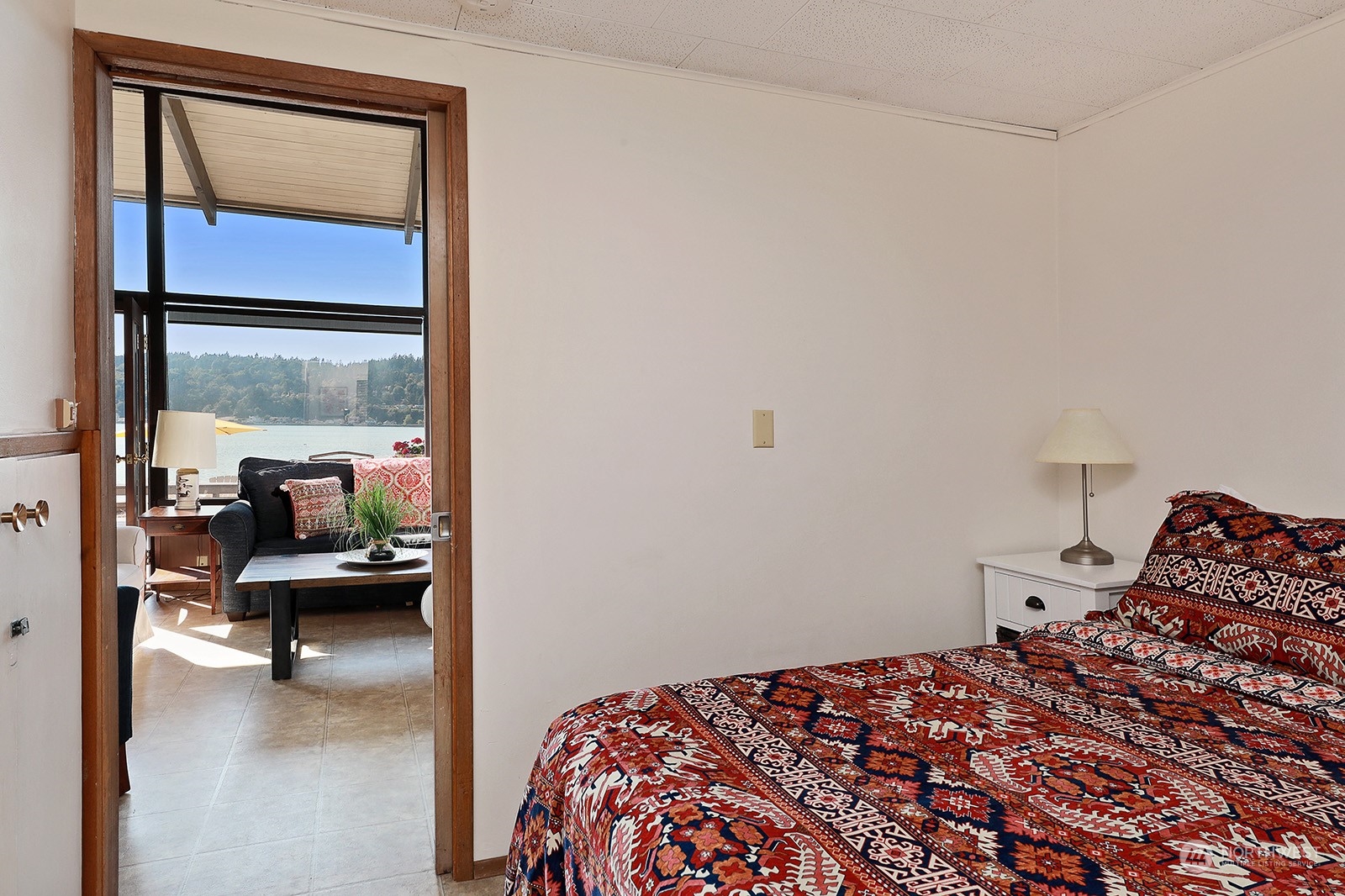 8166 Sandy Hook Drive Clinton, WA 98236 - Photo 26 of 40 a bedroom with a bed and glass window