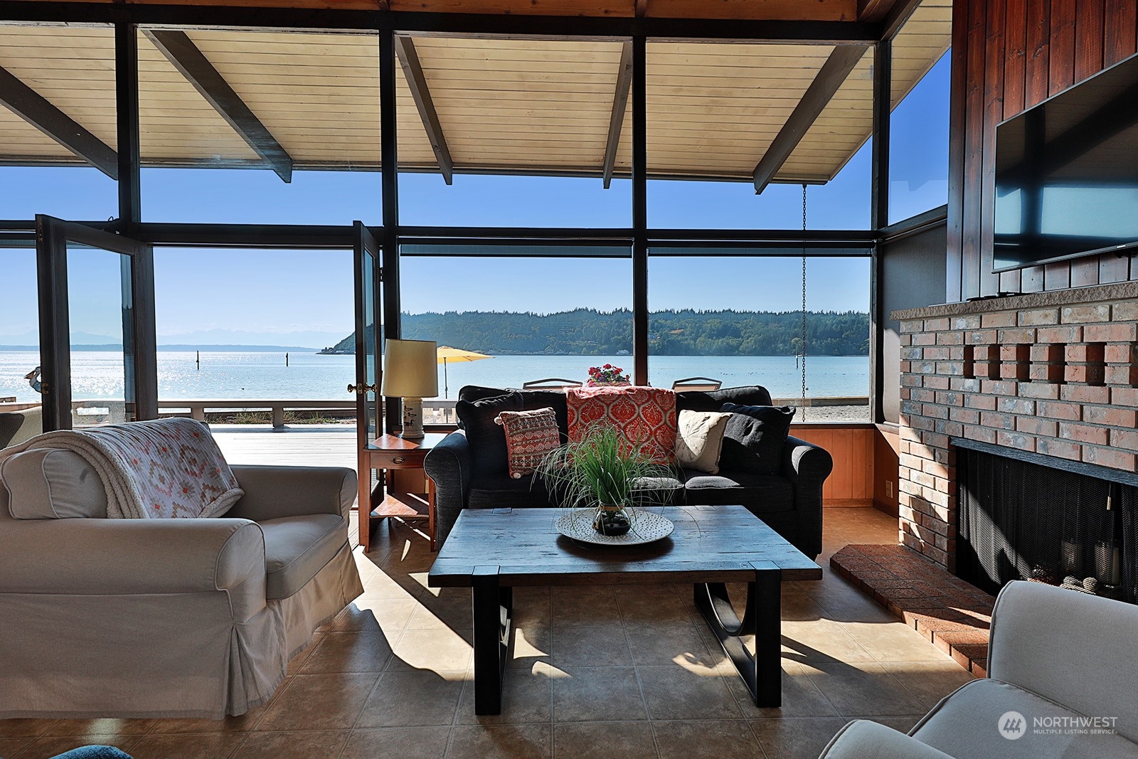 8166 Sandy Hook Drive Clinton, WA 98236 - Photo 10 of 40 a living room with fireplace furniture and a floor to ceiling window