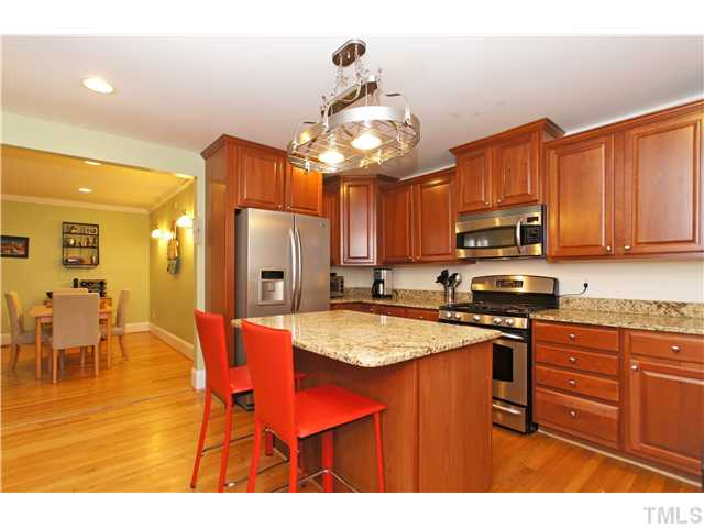2827 Mayview Road Raleigh, NC 27607 - Photo 9 of 24 a kitchen with stainless steel appliances granite countertop a stove refrigerator a microwave oven with a dining table and chairs