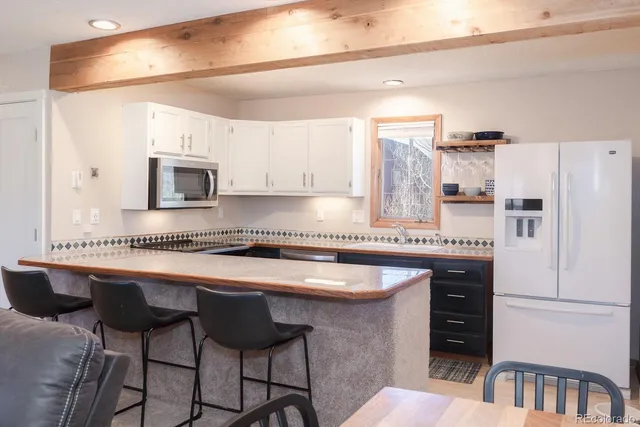 a kitchen with stainless steel appliances granite countertop a white cabinets and a refrigerator