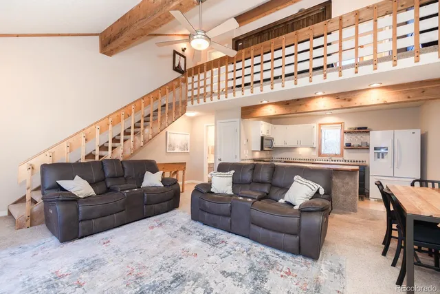 a living room with furniture and a ceiling fan