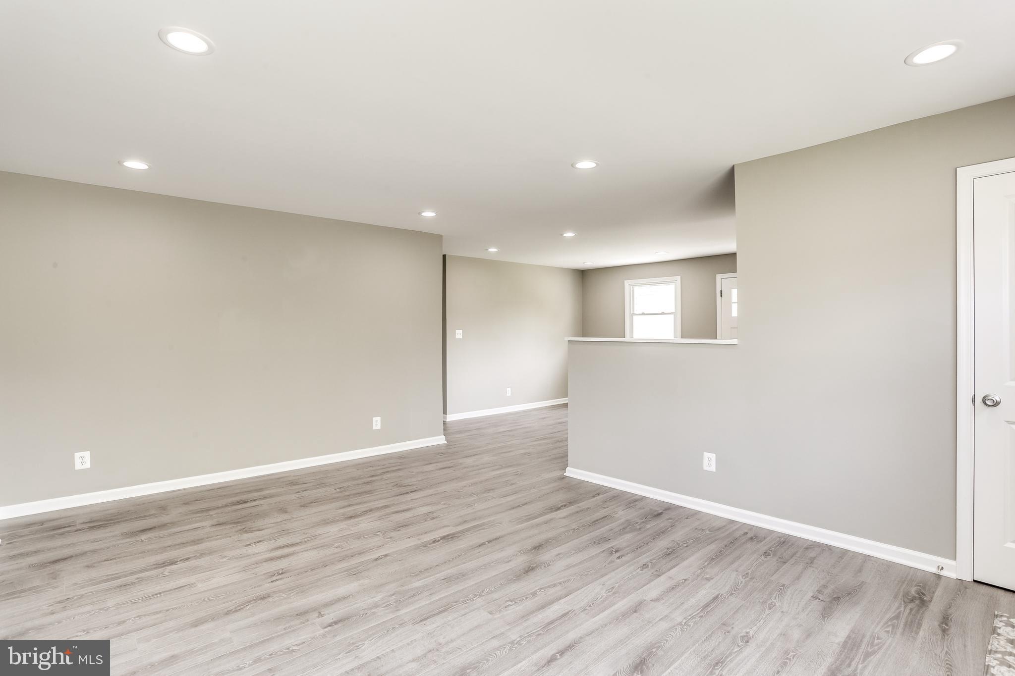 7106 Munford Road Baltimore, MD 21244 - Photo 6 of 31 an empty room with wooden floor and windows