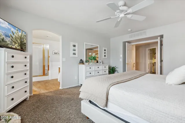 a spacious bedroom with a bed and a chandelier