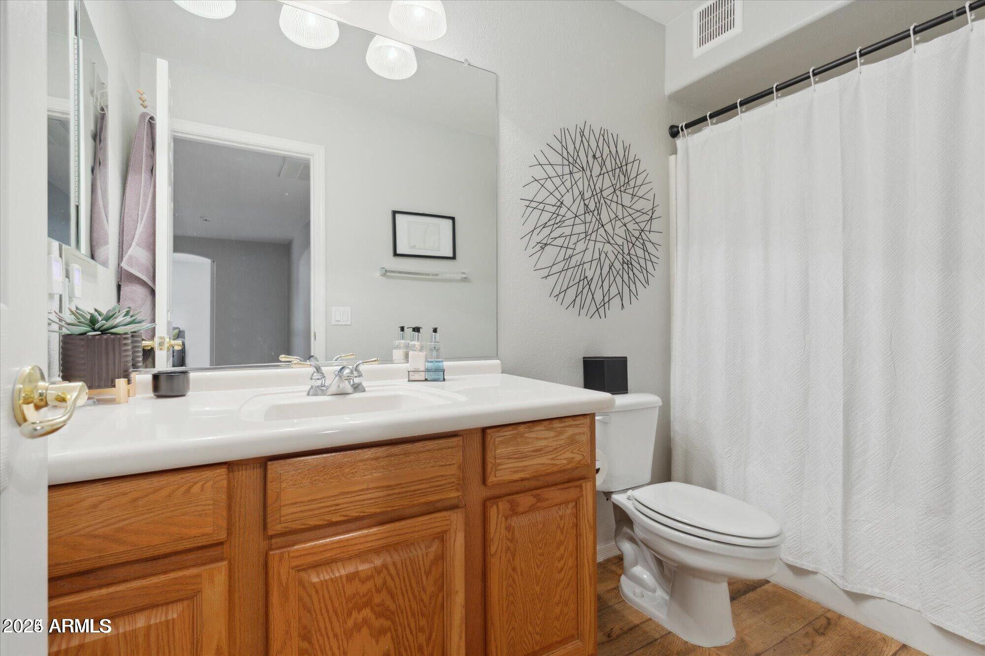 5210 North 16th Drive Phoenix, AZ 85015 - Photo 15 of 26 a bathroom with a toilet a sink and a mirror