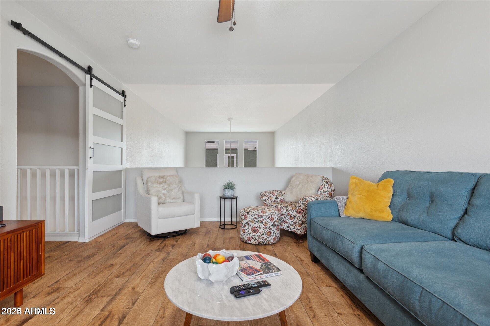 5210 North 16th Drive Phoenix, AZ 85015 - Photo 21 of 26 a living room with furniture and a wooden floor
