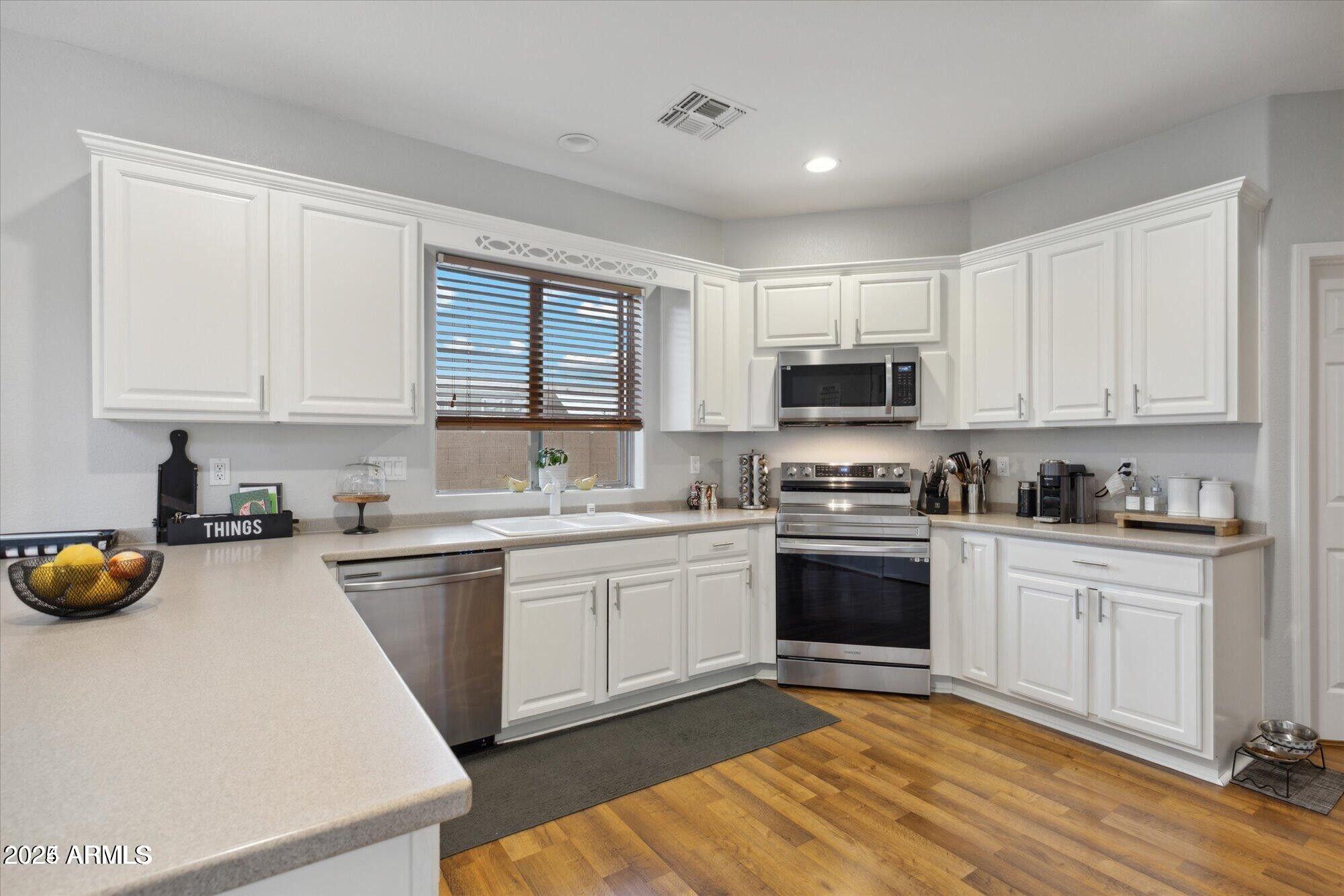 5210 North 16th Drive Phoenix, AZ 85015 - Photo 7 of 26 a kitchen with a sink a stove and cabinets