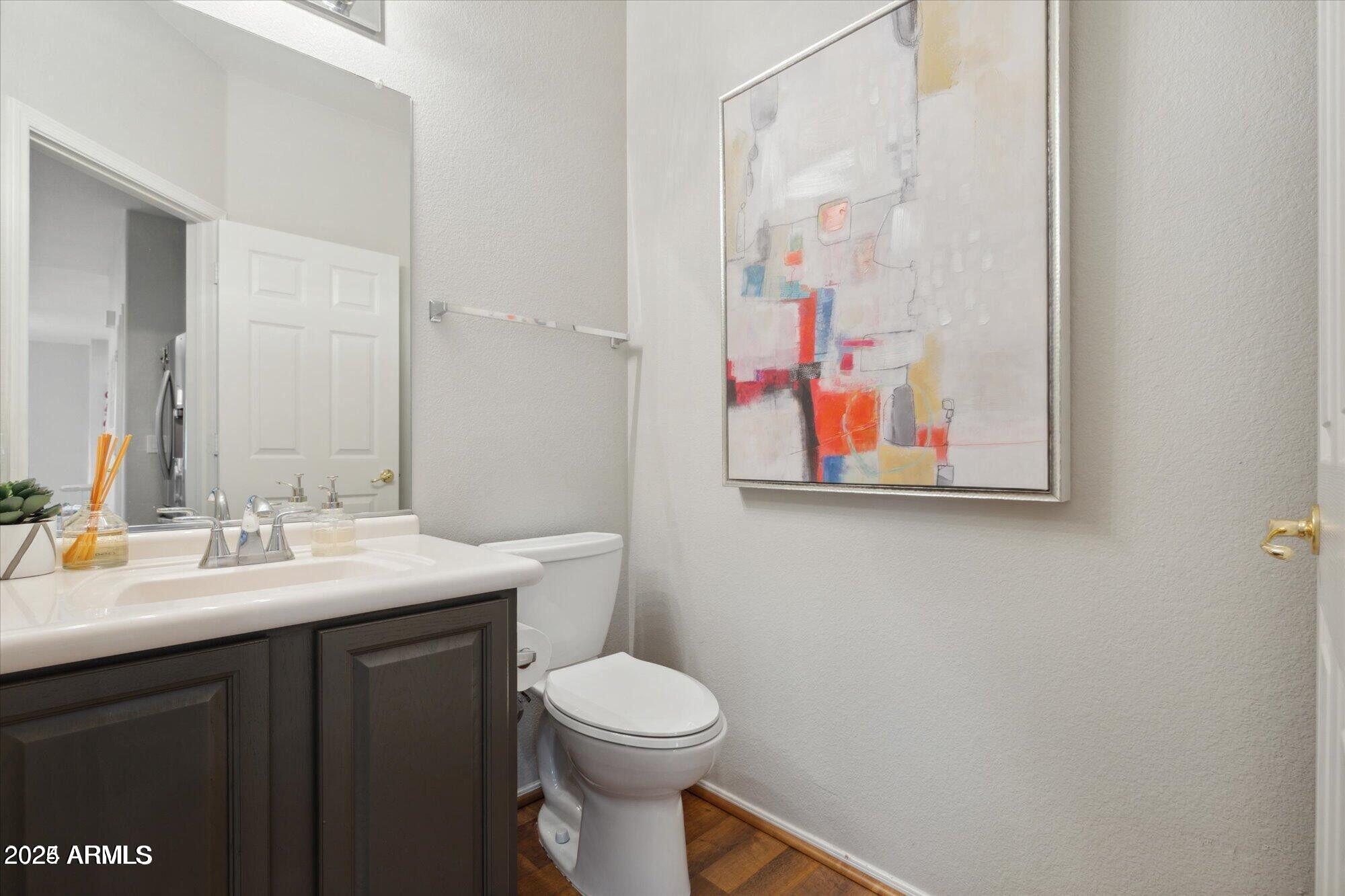 5210 North 16th Drive Phoenix, AZ 85015 - Photo 9 of 26 a bathroom with a toilet a sink and mirror