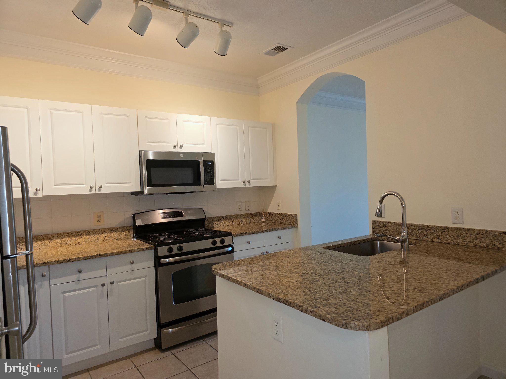 7 Booth Street, Unit 308 Gaithersburg, MD 20878 - Photo 2 of 21 a kitchen with granite countertop a sink and stove top oven