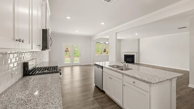 a kitchen with granite countertop stainless steel appliances a sink and cabinets