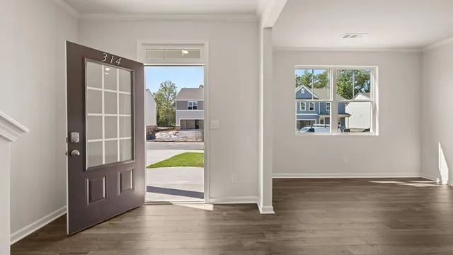 an empty room with wooden floor and a fireplace