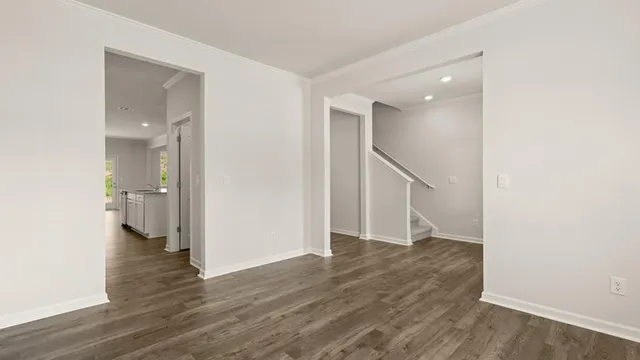 a view of a hallway with wooden floor and staircase