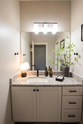 a bathroom with a granite countertop sink and a mirror