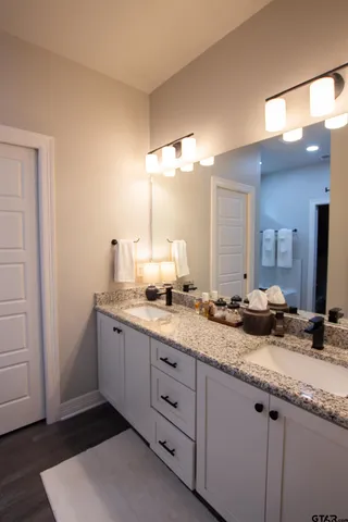 a bathroom with double vanity and a mirror