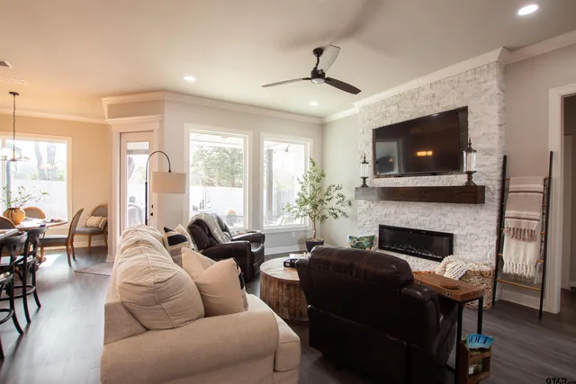 a living room with furniture a flat screen tv and a fireplace