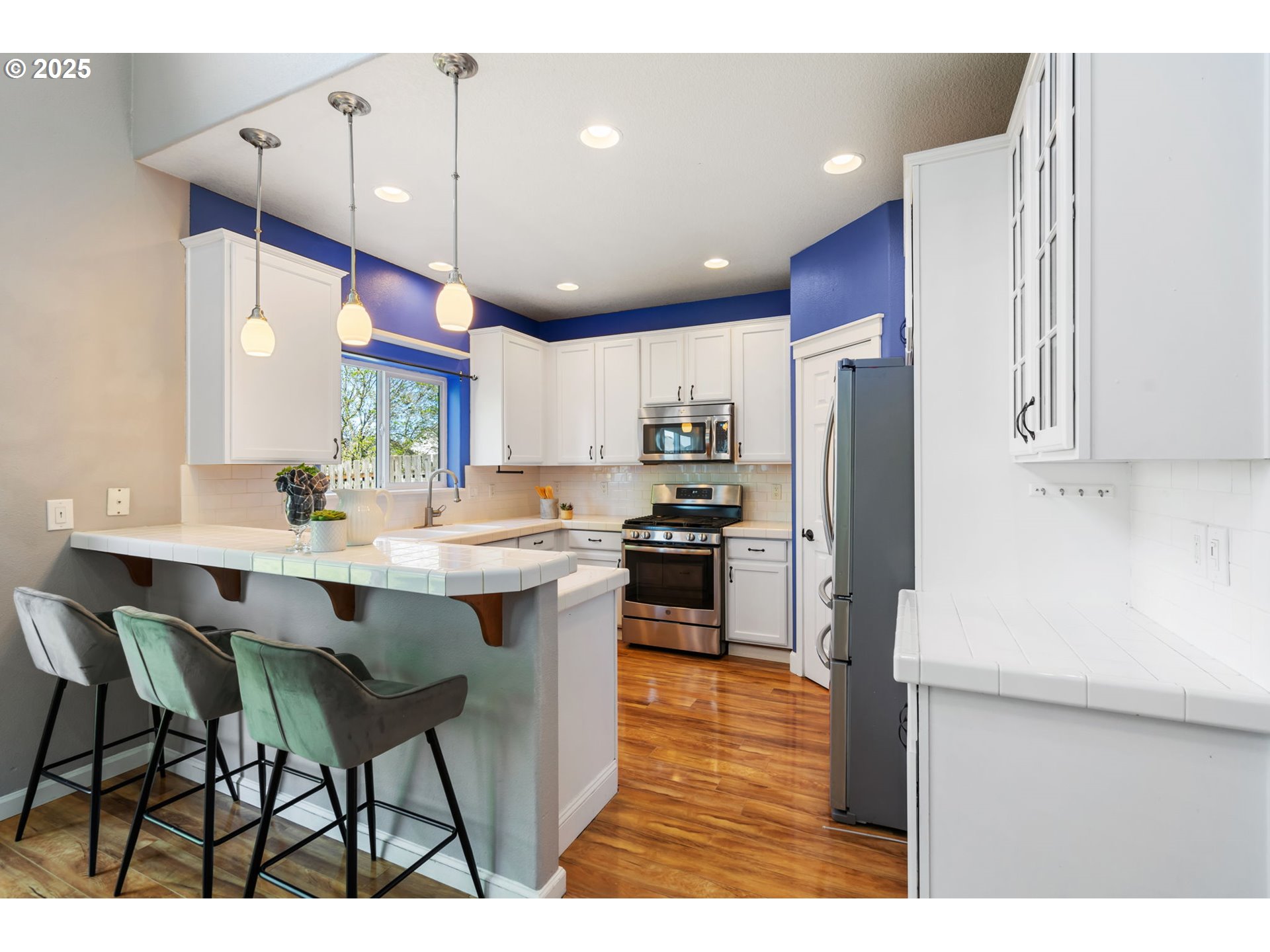 6379 Southeast 31st Terrace Gresham, OR 97080 - Photo 15 of 42 a kitchen with stainless steel appliances kitchen island granite countertop a table chairs and a refrigerator