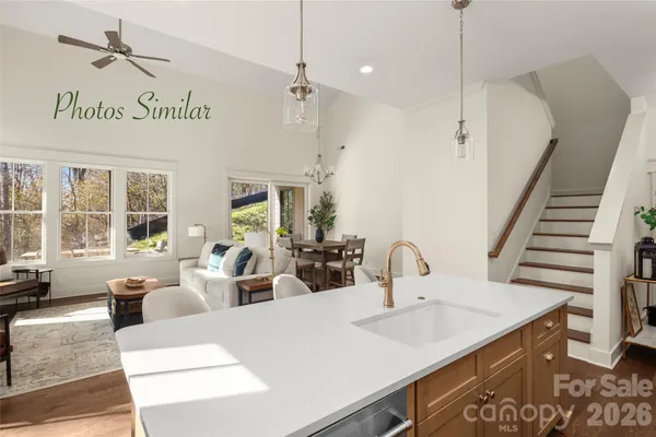 a large kitchen with kitchen island a large counter space appliances and a chandelier