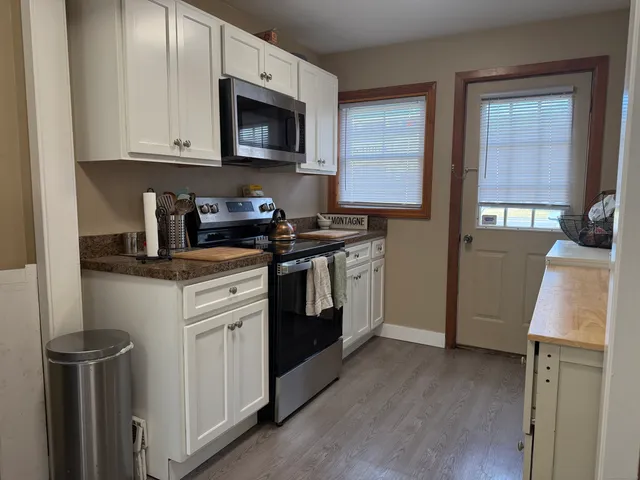 a kitchen with stainless steel appliances granite countertop a stove a microwave a sink and cabinets