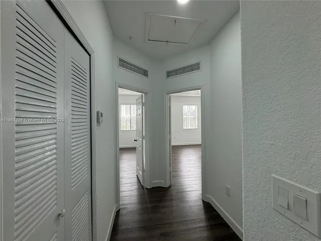 an empty room with wooden floor and closet
