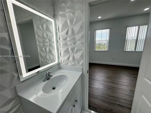 an empty room with wooden floor and entrance