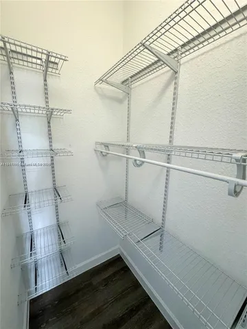 a bathroom with a granite countertop toilet a sink a mirror a window and a shower