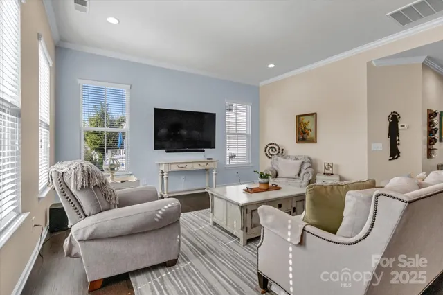 a living room with furniture a flat screen tv and a window