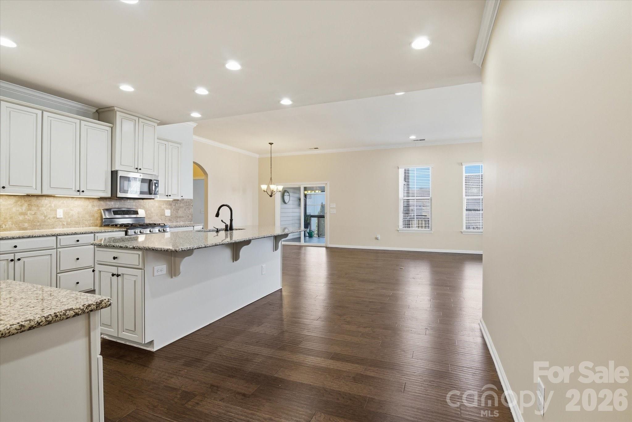 5009 St Clair Street Fort Mill, SC 29715 - Photo 16 of 40 a kitchen with stainless steel appliances granite countertop a stove top oven a sink dishwasher and a refrigerator with wooden floor