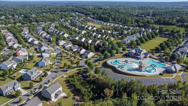 an aerial view of a house with a yard and lake view