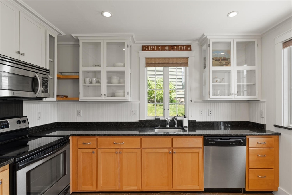 150 Prospect Street, Unit 3 Gloucester, MA 01930 - Photo 6 of 25 a kitchen with stainless steel appliances granite countertop a stove a sink and a microwave