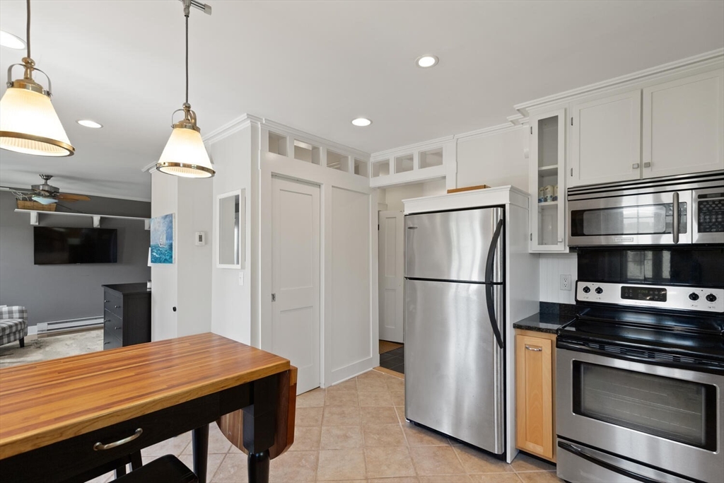 150 Prospect Street, Unit 3 Gloucester, MA 01930 - Photo 7 of 25 a kitchen with stainless steel appliances granite countertop a refrigerator a sink dishwasher a stove and a refrigerator