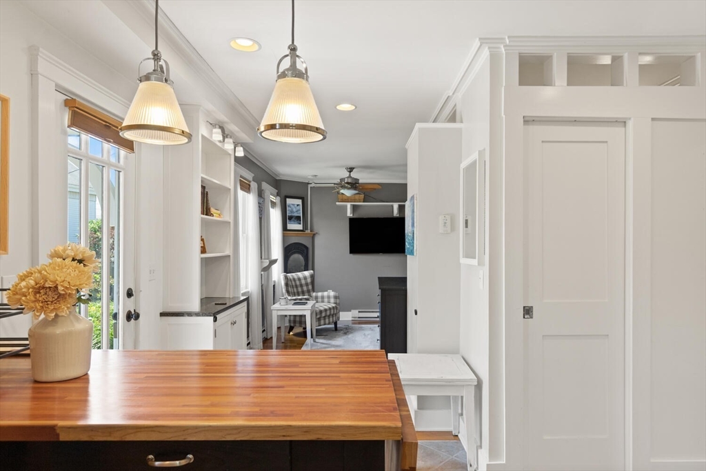 150 Prospect Street, Unit 3 Gloucester, MA 01930 - Photo 9 of 25 a kitchen with stainless steel appliances kitchen island granite countertop a refrigerator a stove and white cabinets with wooden floor