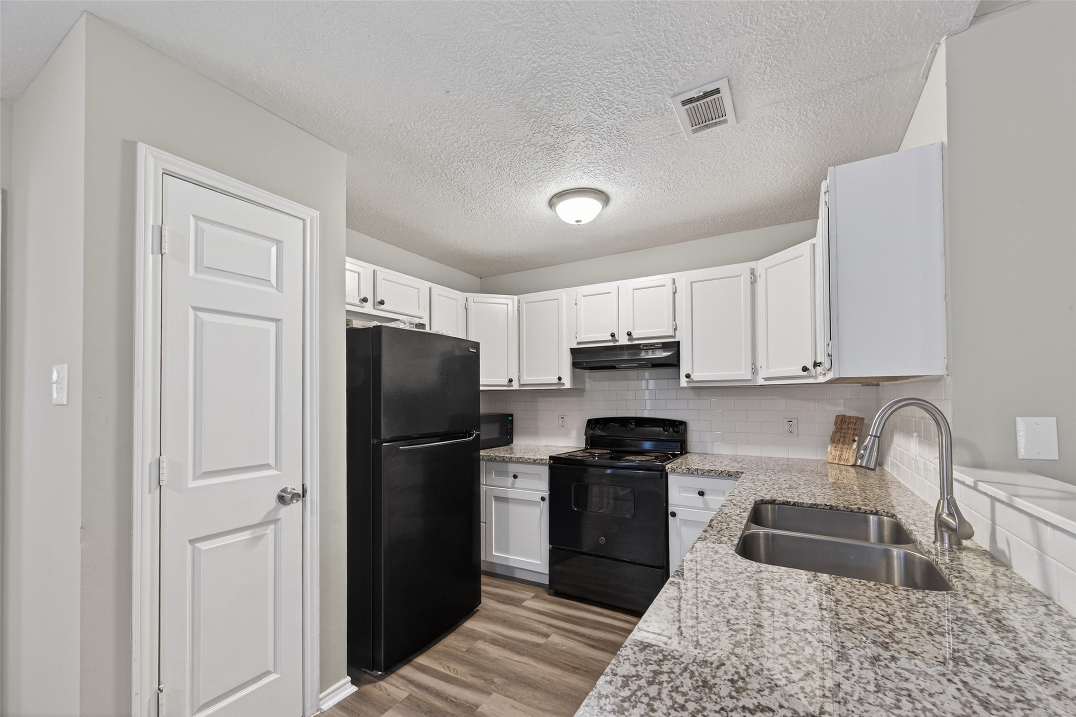 27812 Red Fox Road Tomball, TX 77377 - Photo 13 of 33 a kitchen with a refrigerator sink and cabinets