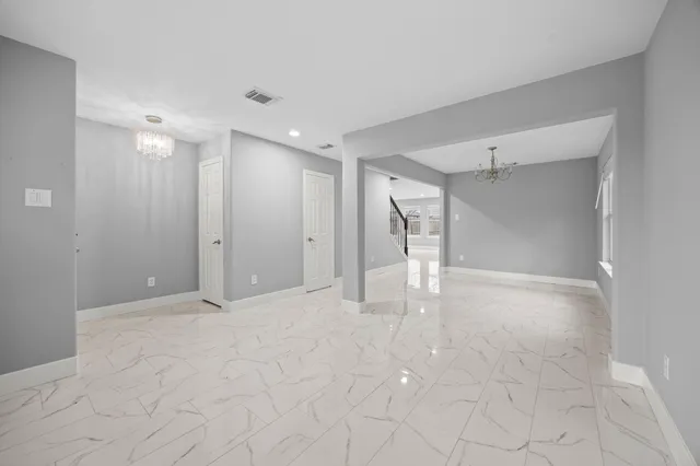 a view of an empty room with windows and cabinet