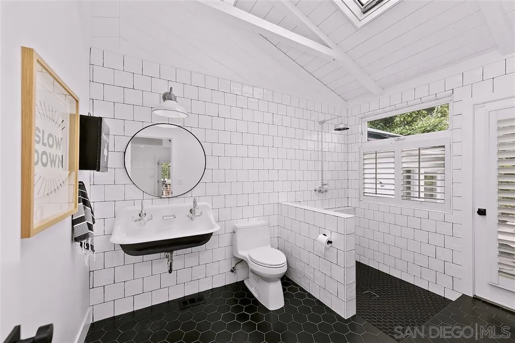 1441 Crest Drive Encinitas, CA 92024 - Photo 15 of 25 a bathroom with a toilet a sink and mirror