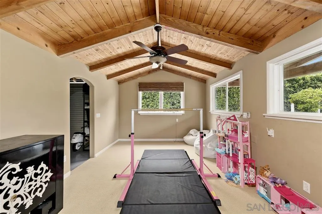 1441 Crest Drive Encinitas, CA 92024 - Photo 19 of 25 a bedroom with a bed and a chandelier