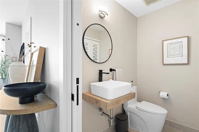 a bathroom with a toilet a sink and a mirror