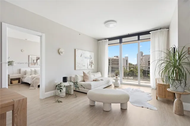 a living room with furniture and a large window with garden view