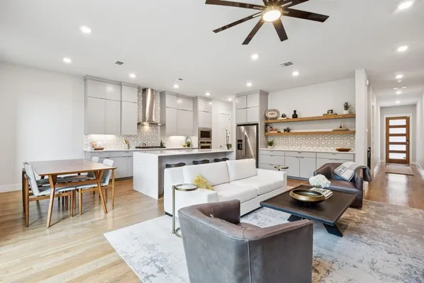 a living room with stainless steel appliances kitchen island furniture and a view of kitchen
