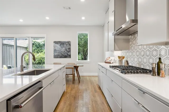 a kitchen with stainless steel appliances a sink stove and cabinets