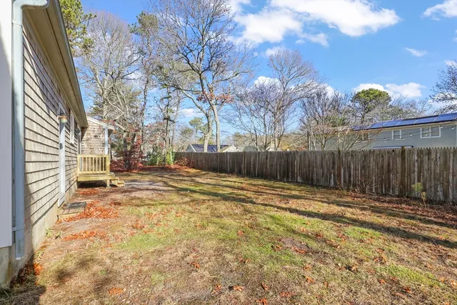 a view of a yard with wooden fence