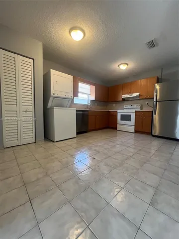 a large room with a lot of stainless steel appliances wooden cabinets and a counter top space