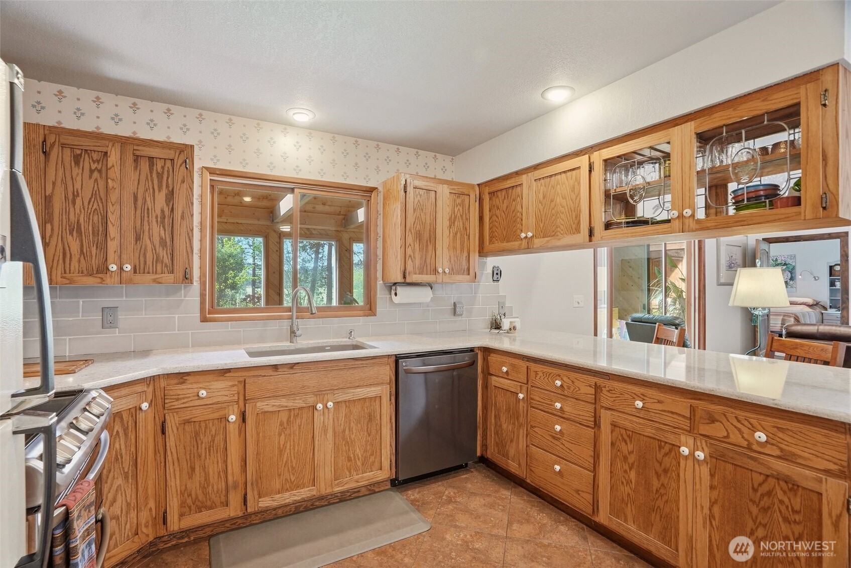 12119 South Spotted Road Cheney, WA 99004 - Photo 10 of 40 a kitchen with stainless steel appliances granite countertop a sink and cabinets with wooden floor